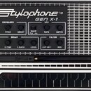 Černý přenosný syntetizátor s nápisem Stylophone™ GEN X-1. Přístroj má ovládací prvky označené jako ENVELOPE, LFO, DELAY a FILTER s doprovodnými popi…
