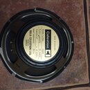 Fotografie znázorňuje zadní stranu černého reproduktoru. Uprostřed je bílý štítek s nápisy: Celestion, MADE IN ENGLAND, Model number G12M, Power capa…