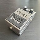 Kovový efekt pedál stříbrné barvy s černým spínacím tlačítkem. Na horní části je nápis FUZZ, označení modelu FZ-1w a značka BOSS. Na spínacím tlačítk…