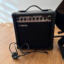 Černý kytarový kombo zesilovač značky YAMAHA, model GA-15. Na horním ovládacím panelu jsou nápisy DRIVE (GAIN, VOLUME), CLEAN (VOLUME) a EQUALIZATION…
