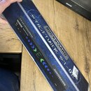 Černý ladicí pedál s nápisem ROCKBOARD StageTuner ST-02. Zařízení má na horní straně ovládací prvky s popisky Input, Mute a CA. Pedál je umístěn na m…