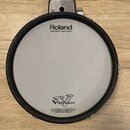 Kruhová elektronická bubenová plocha s bílým napínacím povrchem a černým gumovým okrajem. V horní části je nápis Roland a pod ním text MESH HEAD™ mad…
