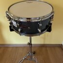 Tmavě šedý buben s kovovými obručemi a napínacími šrouby umístěný na chromovaném stojanu. Na koruse je vidět logo REMO a na korpusu nápisy DRUM oraz…