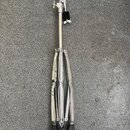 Stříbrný kovový stativ s černými gumovými koncovkami nožiček. V horní části je umístěn černý úpínací mechanismus s šroubem. Na povrchu nejsou vidět ž…