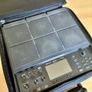 Černý sampling pad Roland SPD-SX PRO v černém polstrovaném přenosném pouzdře. Zařízení obsahuje devět velkých čtvercových padů, displej a ovládací pr…
