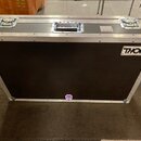 Černý transportní flightcase s hliníkovými hranami a kovovými rohy. Na horní části jsou dvě zapínací zámky a jedna úchytová rukojeť. V pravém horním…