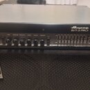Černý basový zesilovač s nápisem Ampeg SVT-3 PRO umístěný na černé basové reproducing box s logem Ampeg. Přední panel zesilovače obsahuje ovládací kn…