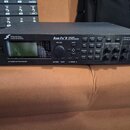 Černý rackový procesor s nápisem FRACTAL AUDIO SYSTEMS a označením Axe-Fx II PREAMP / FX PROCESSOR. Zařízení má displej, několik tlačítek, otočný ovl…