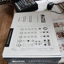 Na fotografii je zobrazen mixážní pult v originální krabici a stejný přístroj vybalený vedle ní. Na krabici i na přístroji je viditelné logo ALTO PRO…