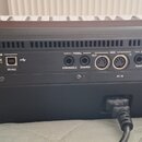 Zadní strana černé digitální klávesy s řadou konektorů a ovládacích prvků. Jsou zde viditelné nápisy: VIDEO OUT, USB HOST, USB DEVICE, PEDAL ASSIGNAB…