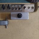 Detail zadní části zesilovače s béžovým potahem. Na kovovém panelu jsou nápisy FOOT SWITCH, POWER PREAMP, AMP IN a CUT, dále přepínače s označením ST…