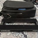 Černý kovový pedalboard s dvěma vodorovnými nosnými lištami. Na spodní hraně je bílý nápis pedaltrain® U.S. Pat. No. 7,439,023 a označení nano. Vedle…