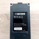 Zadní strana černého efekt pedálu značky BOSS. Na spodní části je štítek s nápisy „Roland Corporation“, „2036-1 Nakagawa, Hosoe-cho, Kita-ku, Hamamat…