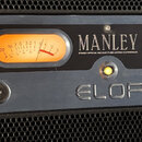 Rackové studio zařízení v černé barvě s nápisem MANLEY a pod ním text STEREO OPTICAL VACUUM TUBE LIMITER COMPRESSOR. Uprostřed spodní části je výrazn…