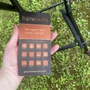 Fotografie zachycuje ruku držící produktový štítek značky GATOR frameworks. Štítek obsahuje nápis „We support your music...literally.“ a seznam kateg…