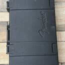 Černý tvrdý kufýr na hudební nástroj z plastového materiálu. Uprostřed je vyraženo logo Fender®. Povrch vykazuje drobné škrábance a známky běžného po…