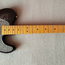 Elektrická kytara typu Telecaster s černým korpusem, který je zdoben šedivým ornamentem paisley. Kytara má šedý plech s podobným vzorem, javorový hma…