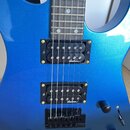 Modře metallic elektrická kytara s hnedým hmatníkem a bílými tečkovými značkami. Nástroj má dva černý humbuckery, na kterých je bílý nápis duncan. Na…