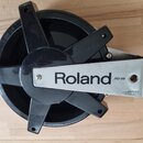 Černý elektronický pad s kovovou oporou. Na stříbrném štítku je uveden nápis Roland PD-85 a v pravém dolním rohu text FREE USE UNDER U.S. PATENT No.…