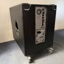 Černý aktivní subwoofer v kostkovém provedení s kovovými madly a kolečky. Na zadním panelu je nápis STEREO ACTIVE SUBWOOFER, označení modelu SUB 05 a…