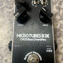 Stompbox s kovovým stříbrným povrchem a černým spodním panelem. Na horní části jsou tři černé ovládací knoflíky s popisky LEVEL a DRIVE, dva přepínač…
