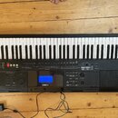 Černý digitální klavír s bílými a černými klávesami. Na předním panelu je modrý displej a nad ním bílý nápis YAMAHA. Nástroj obsahuje řadu ovládacích…