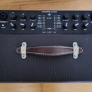Černý kytarový kombozesilovač s nápisem ACOUSTIC JUNIOR. Horní ovládací panel obsahuje dva vstupy označené CHANNEL 1 a CHANNEL 2, několik otočných po…