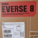Fotografie zachycuje detail kartonového obalu s produktovými štítky. Horní červený štít nese nápis WHITE EVERSE 8 WEATHERIZED BATTERY-POWERED LOUDSPE…