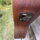 Detailní pohled na boční část hnědé akustické kytary s integrovaným předzesilovačem. Černý ovládací panel nese nápis D'Angelico Standard a označení M…