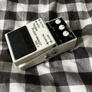 Bílý efekt pedál s černým spínacím tlačítkem. Na horní straně je nápis boss NS-2 Noise Suppressor a označení konektorů OUTPUT, SEND, RETURN a INPUT.…