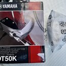 Fotografie zobrazuje krabičku s produktem a bílý plastový sáček. Na krabičce je logo YAMAHA a nápisy DRUM TRIGGER, CAPTEUR POUR FÛT DE BATTERIE, DISP…