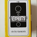 Žlutá krabice s obrázkem efekt pedálu. Na černém pozadí je bílý nápis LPB-1 a LINEAR POWER BOOSTER, nad nimi nápis BOOST a v horní části značení 9V.…