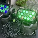 Dvě černé LED par lampy s obdélníkovým tvaru svítící plochou, umístěné na černém transportním case. Na každé lampě je vidět nápis "ROSSY". Před příst…