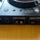 Detail zadní strany černého DJ kontroléru s nápisem DDJ-400 a logem Pioneer DJ. Jsou vidět konektory USB, MASTER (prava červený a levý bílý RCA) a MI…