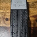 Černý expresní pedál s gumovou protiskluzovou texturou ve tvaru ševronů. Na horní šedé části je vyražen nápis Roland EV-5. Povrch pedálu vykazuje mír…
