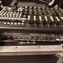 Černý kontrolní povrch s bílými tlačítky, posuvníky a ovládacími knoflíky. Na zařízení jsou viditelná loga behringer a nápisy X-TOUCH, UNIVERSAL CONT…