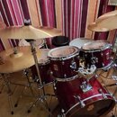 Celá bicí souprava v tmavě červené barvě s kovovým hardwarem. Na tomu a snare drumu je viditelné logo „PD“. Souprava obsahuje basový buben, dva tom-t…