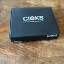Černá kartonová krabice s logem CIOKS a nápisem Future Power Generation. Na boční straně je rovněž logo CIOKS a webová adresa cioks.com. Povrch krabi…