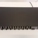 Černý obdélníkový elektronický přístroj s řadou ovládacích prvků v podobě posuvníků na přední straně. Na pravé straně je vidět nápis KAWAI a pod ním…