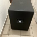Černý subwoofer s texturovaným povrchem a hranatým tvarem. Na zadní straně je umístěn štítek s nápisy DYNACORD a Sub S 115. Horní plocha obsahuje kov…