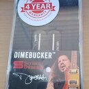 Průhledný plastový obal obsahuje dva elektrické kytarové snímače typu humbucker v černé barvě. Na snímačích jsou viditelný nápis "Duncan" a podpis. V…