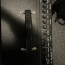 Černý kytarový kombozesilovač s texturovaným povrchem a plastovou rukojetí. Na ovládacím panelu je nápis KATANA-100 a logo značky Boss. Panel obsahuj…