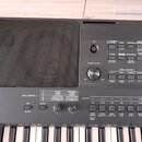 Černý digitální klavír s integrovaným reproduktorem vlevo. Na ovládacím panelu jsou viditelné nápisy PORTABLE GRAND, DEMO, TRANSPOSE a MELODY SUPPRES…