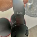 Černé centerXlupovací sluchátka s nápisem studio na náhlavníku. Na vnější straně mušle je viditelné logo ve tvaru stylizovaného písmene S. Povrch pla…