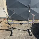 Chromovaný bubnový rack s několika rameny a uchopovadly. Na středové tyči je viditelný nápis Gibraltar. Konstrukce vykazuje běžné známky používání a…