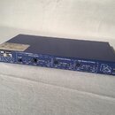 Modrý rackový zesilovač s černým předním panelem. Na panelu jsou nápisy NEXO, LF Eq & LS1200, Left Passive/LF Active a Right Passive/HF Active, vprav…