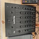 Černý mixážní pult s nápisy Numark a M6 USB. Zařízení obsahuje čtyři kanály s posuvníky, korekční knofíky a ovládací prvky pro master a cue. Povrch j…