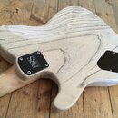 Zadní strana elektrické kytary s viditnou strukturou světlého dřeva. Na krku je černý kryt s bílým nápisem PRS GUITARS. V dolní části těla se nachází…