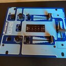 Modrý DJ mixér s bílými označením a ovládacími prvky. Na levé straně je svisle napsáno OMNITRONIC a vedle toho model DJ-25. Přístroj obsahuje posuvní…