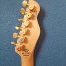Fotografie zachycuje hlavu elektrické kytary z přírodního světlého dřeva se šesti zlatými ladičkami. Na hlavě je černý nápis CHAPMAN GUITARS, ML3 PRO…